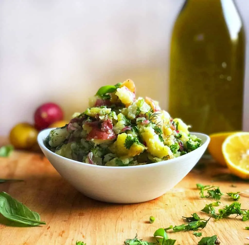 potato salad in a bowl with olive oil in the background