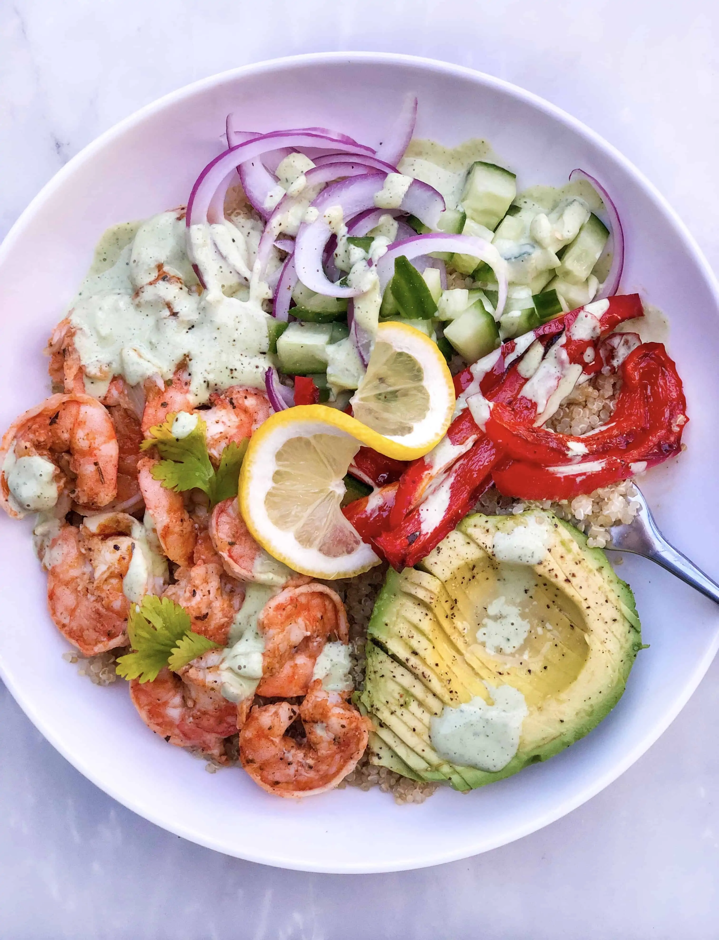 shrimp quinoa bowl with lemon, red bell pepper, red onions, and avocado
