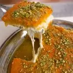 Knafeh Na'ameh close up on cheese pull and pistachio topping