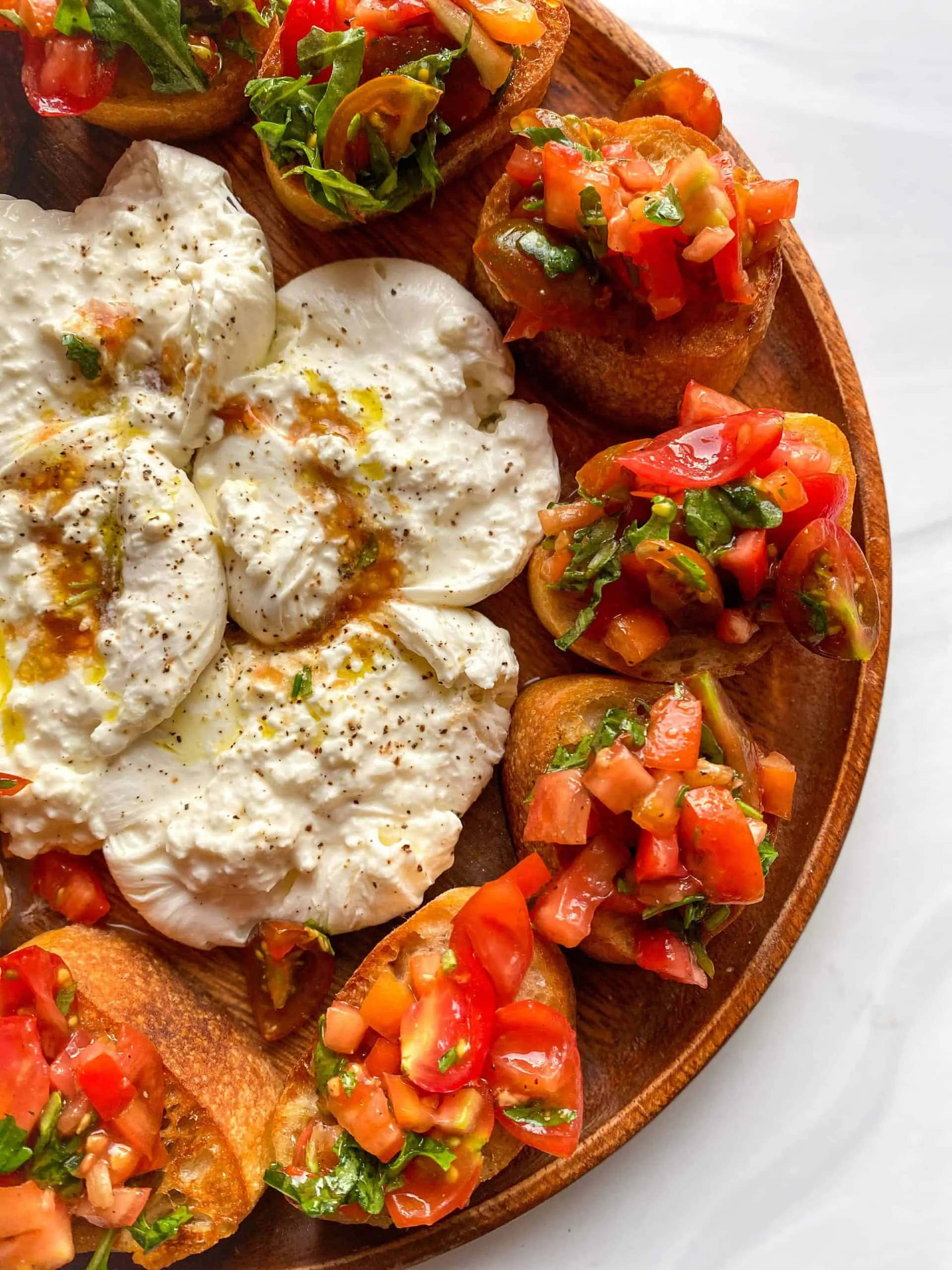 Easy Bruschetta close up with burrata in the center topped with olive oil