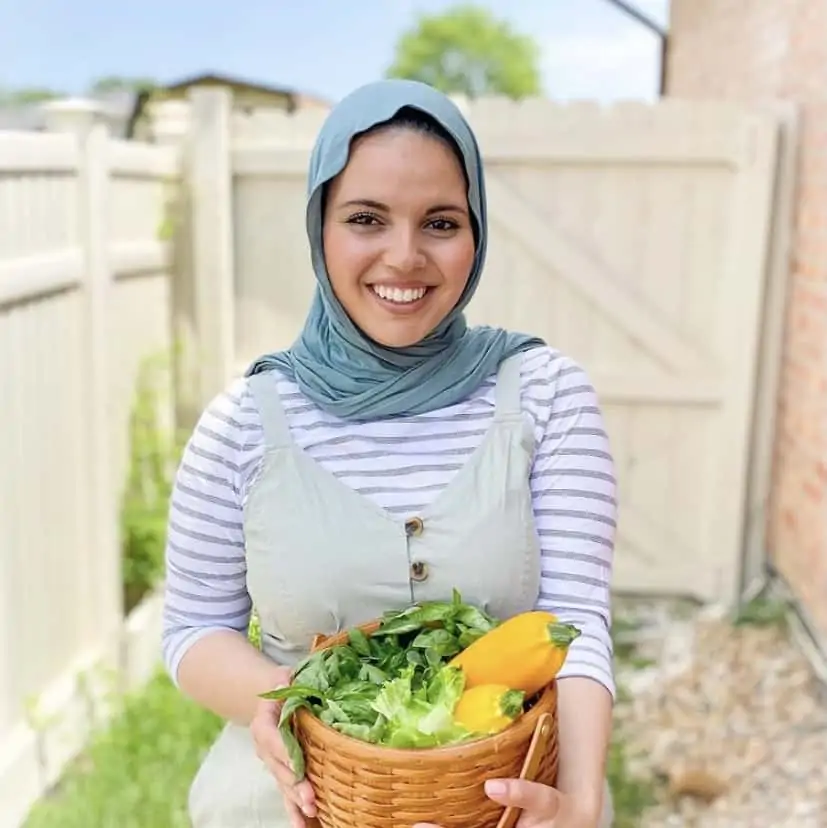 Fufu in her garden holding a basket of vegetables