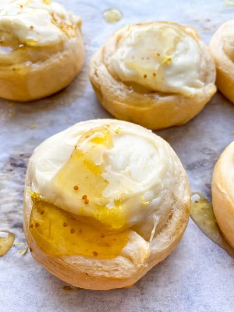 cheese danish on parchment paper with honey on top