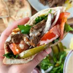 top view beef shawarma in a pita bread with onion, meat, tomatoes, and pickles