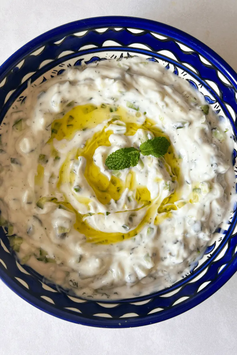 bowl of cucumber yogurt salad (khyar bi laban) and olive oil with mint
