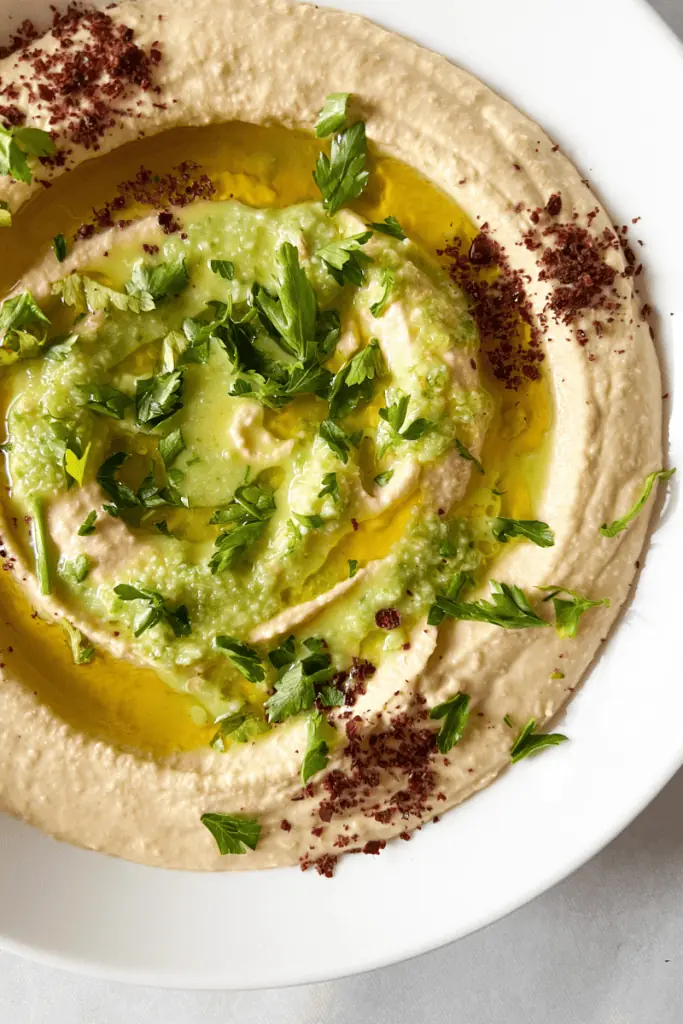 Simple and authentic hummus recipe topped with sumac, parsley, jalapeno sauce and olive oil.