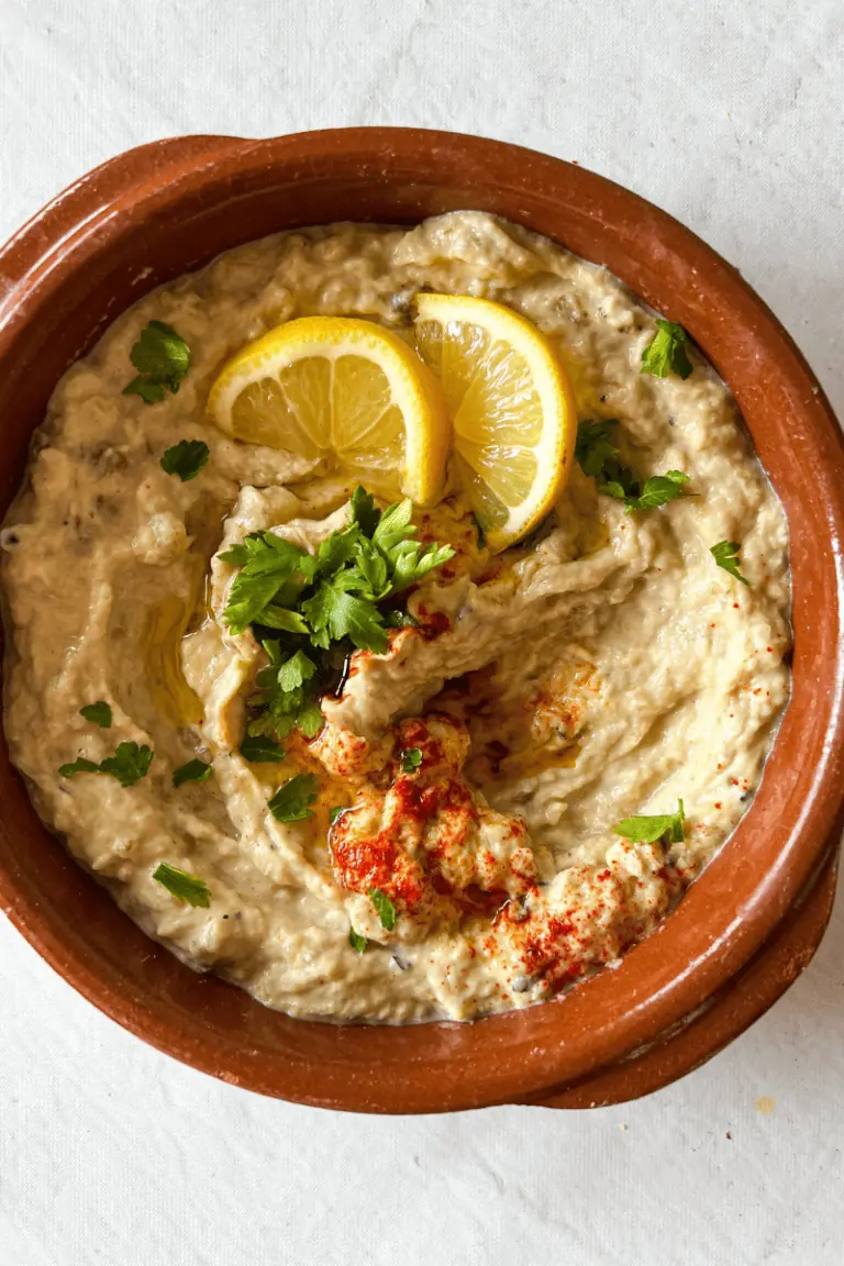 Baba Ghanoush (Roasted Eggplant Dip) topped with parsley, paprika, and lemon slices