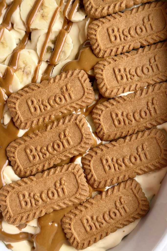 Biscoff cookies layered on top of cream for banana pudding recipe