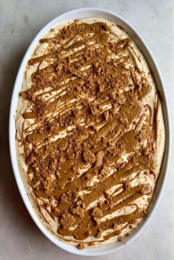 Biscoff banana pudding topped with crushed cookies and cookie butter drizzle